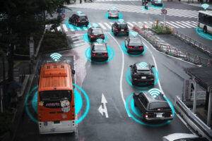 Multiple vehicles on a city street with blue digital connectivity rings, illustrating vehicle-to-everything (V2X) communication.