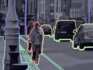 Polygon-annotated street scene highlighting vehicles, a cyclist, and road features