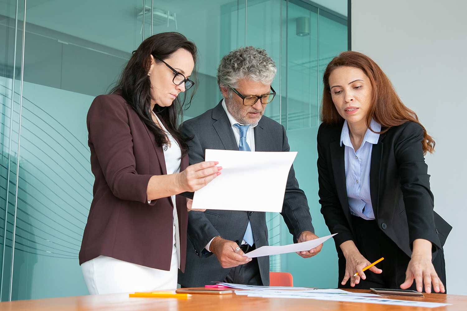Executives reviewing documentation during a vendor evaluation meeting.