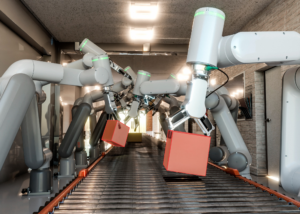 Robotic arms sorting boxes on a conveyor, showing automated manipulation